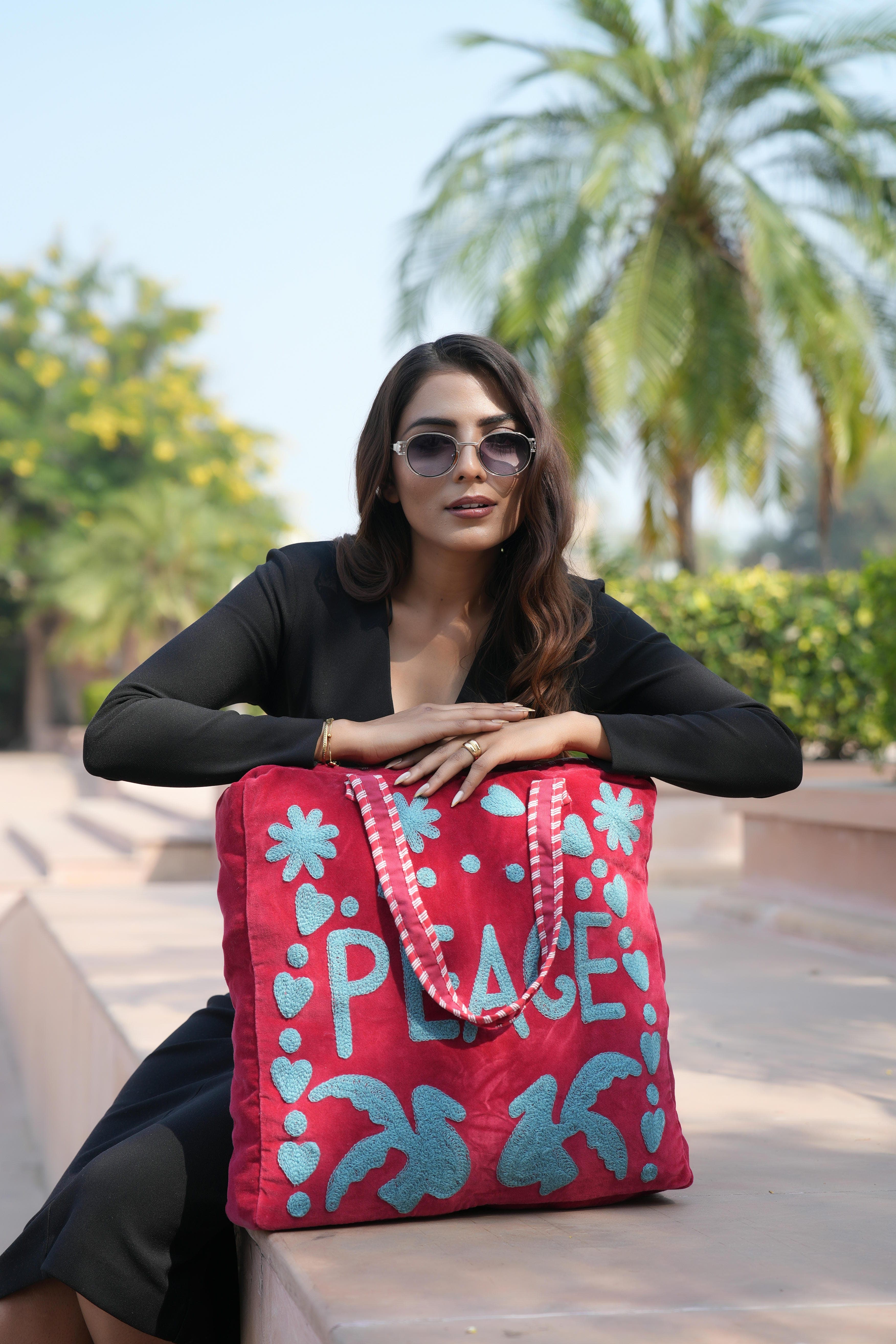 Model carrying the Peace Suzani Tote on the shoulder over a linen dress