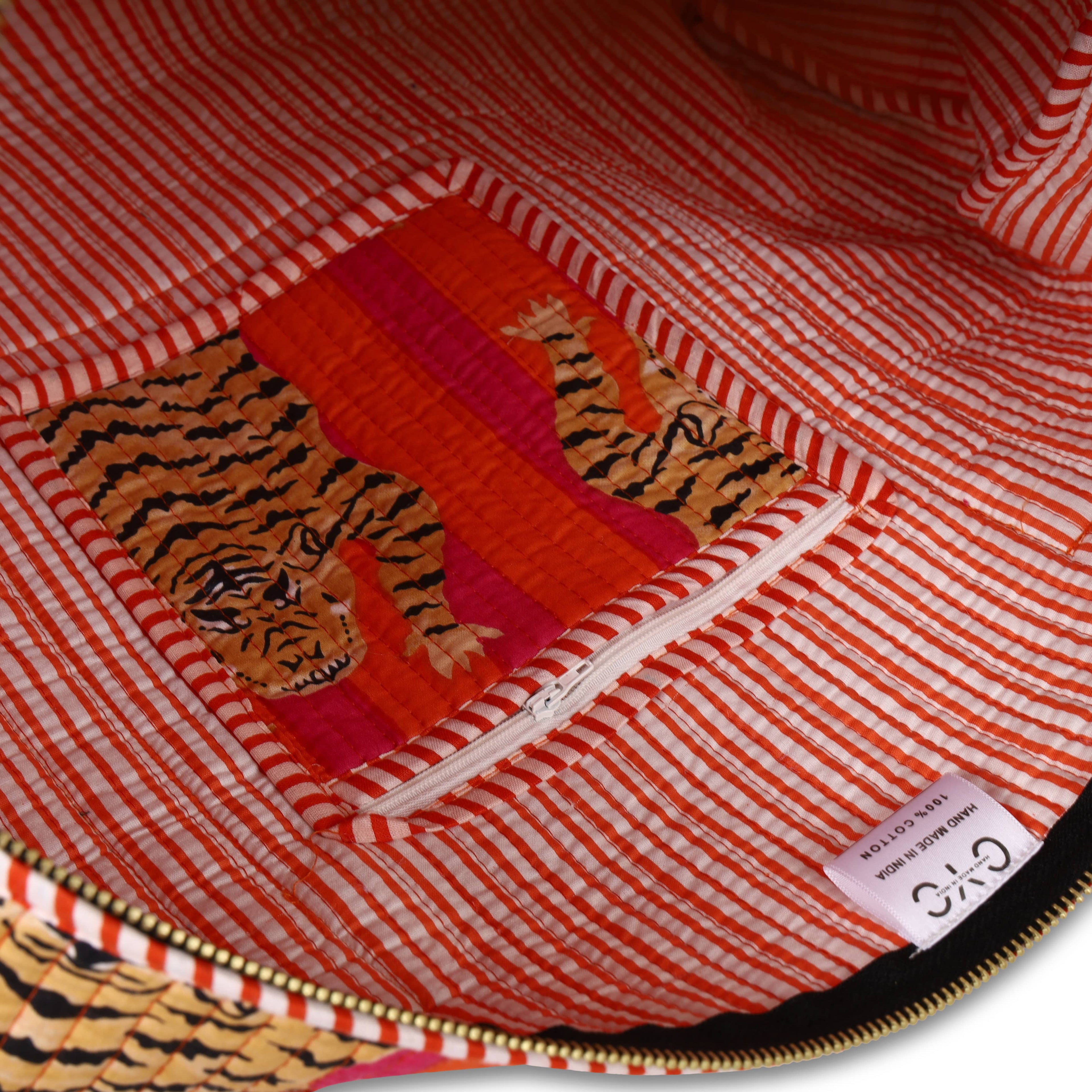 Open view of The Tibetan Tiger Weekender showing the wide top zipper, cotton-lined interior, and inside pocket