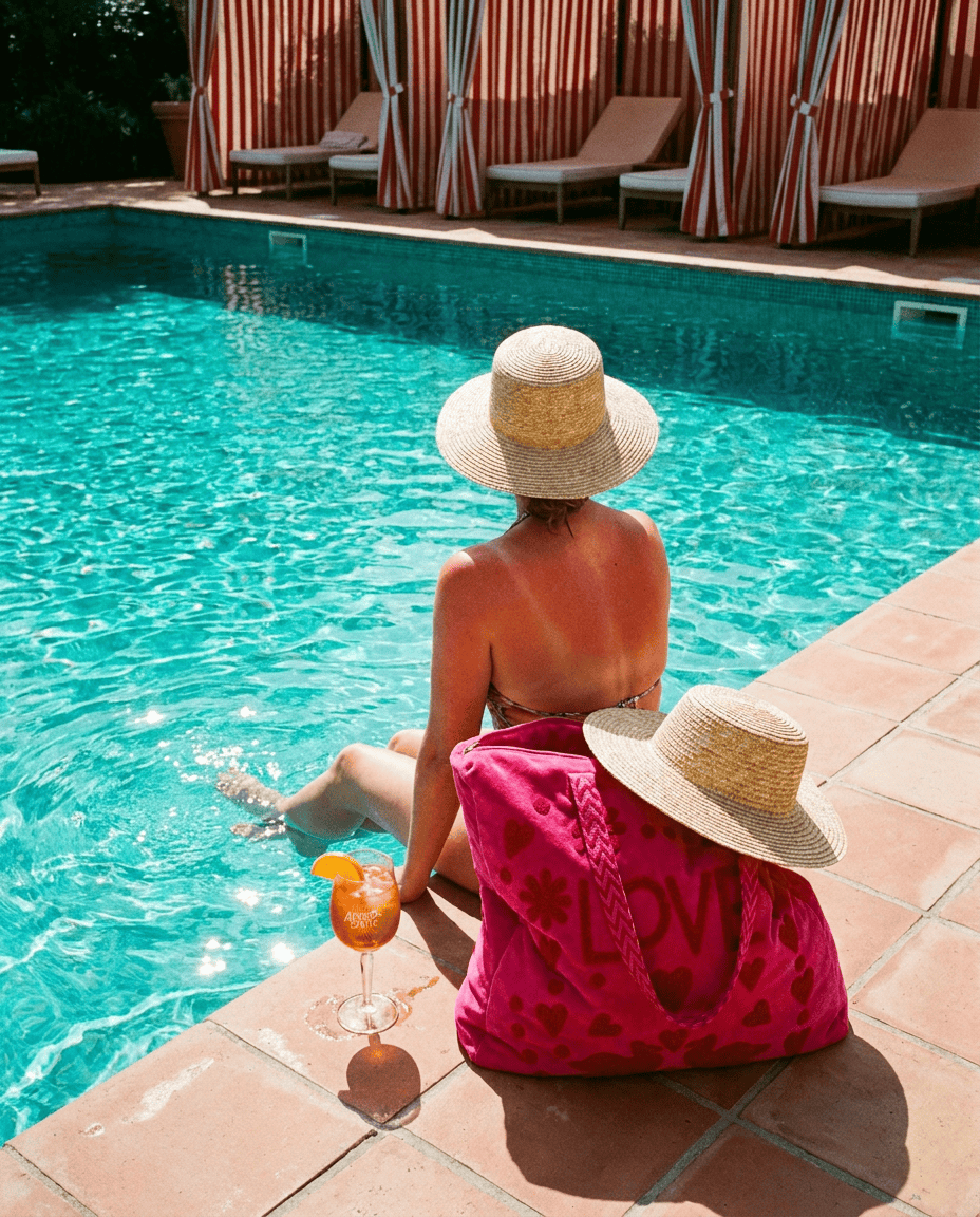 Legs dangling in the pool with the Love Suzani Velvet Tote in Hot Pink on the tile — handmade in Rajasthan by Conscious Yoga Collective