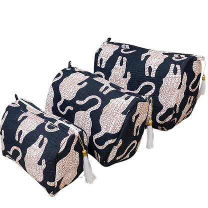 Set of four navy blue pouches with white elephant patterns on a white background