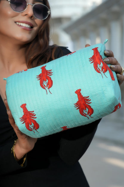 The Lobster Travel Set — mint pouch held out to camera showing the red lobster motif; handmade cotton travel pouch set, ethically made in Rajasthan.
