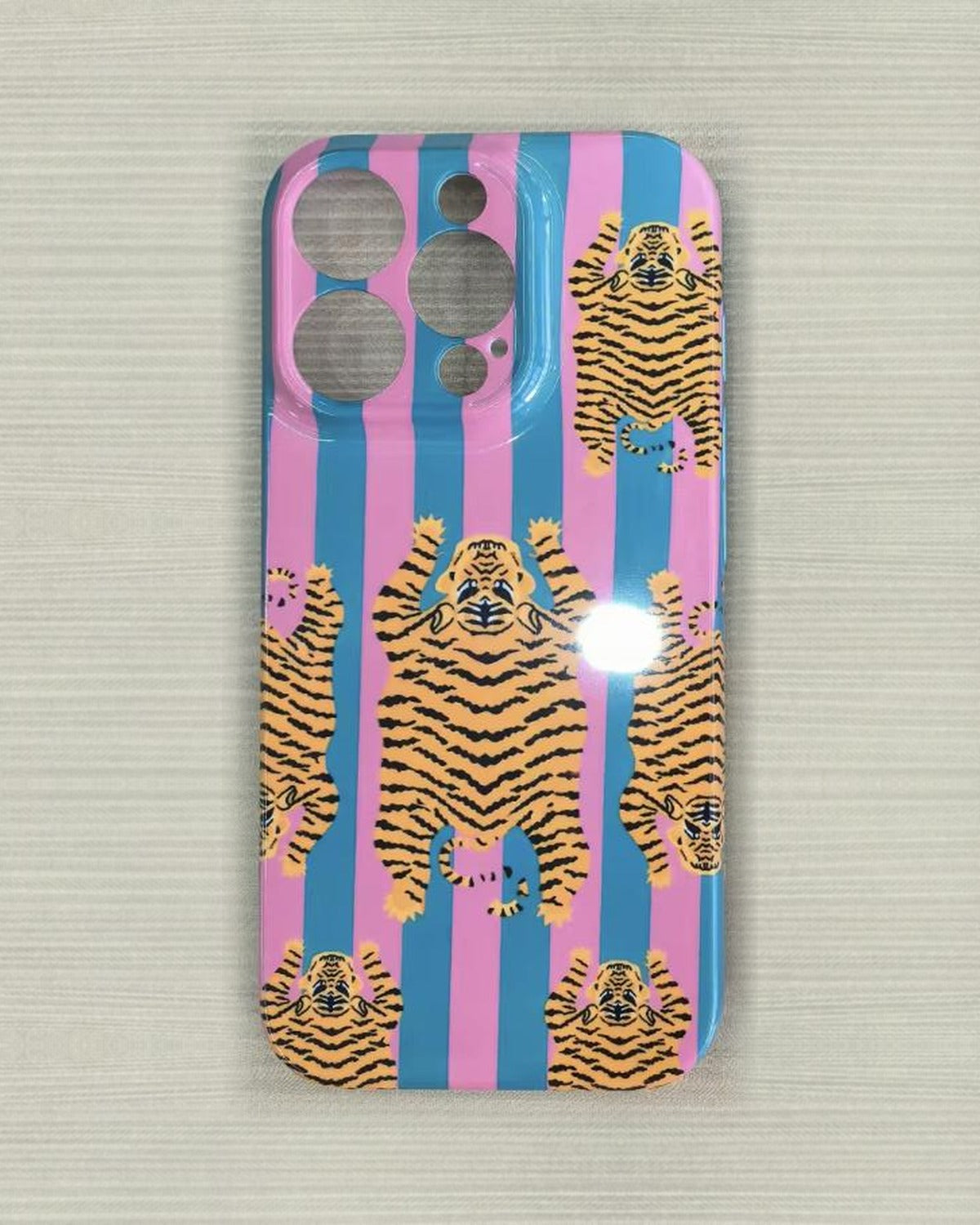 The Tibetan Tiger iPhone Case in Pink and Teal — close view of the glossy printed back and camera cutout