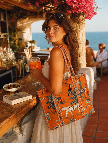 Italian café aperitivo with the Leopard Tote in orange — Aperol in hand, hand-block-printed cotton from Conscious Yoga Collective