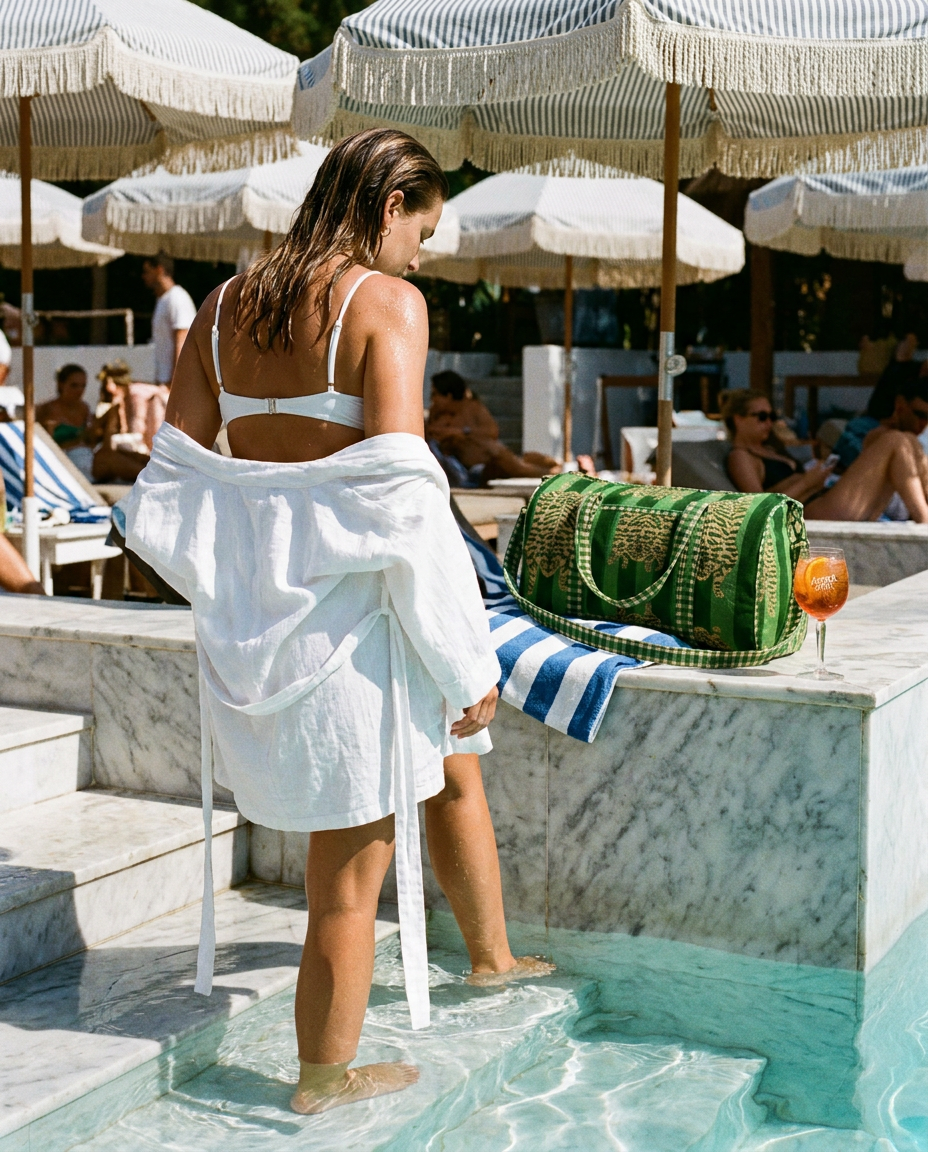 Woman on marble pool steps with the Tibetan Tiger Velvet Weekender in Green on the ledge — handmade in Rajasthan by Conscious Yoga Collective