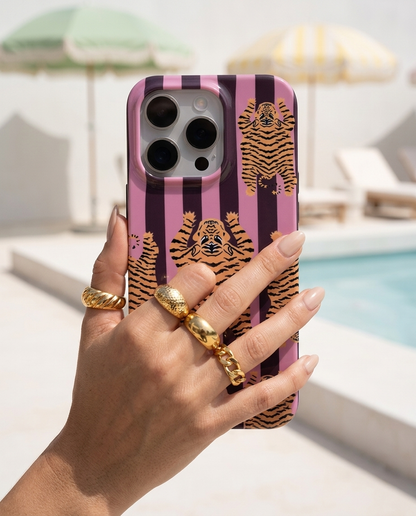 The Tibetan Tiger iPhone Case in Mauve Plum in a modern editorial poolside shot with pistachio parasols and chalk white concrete