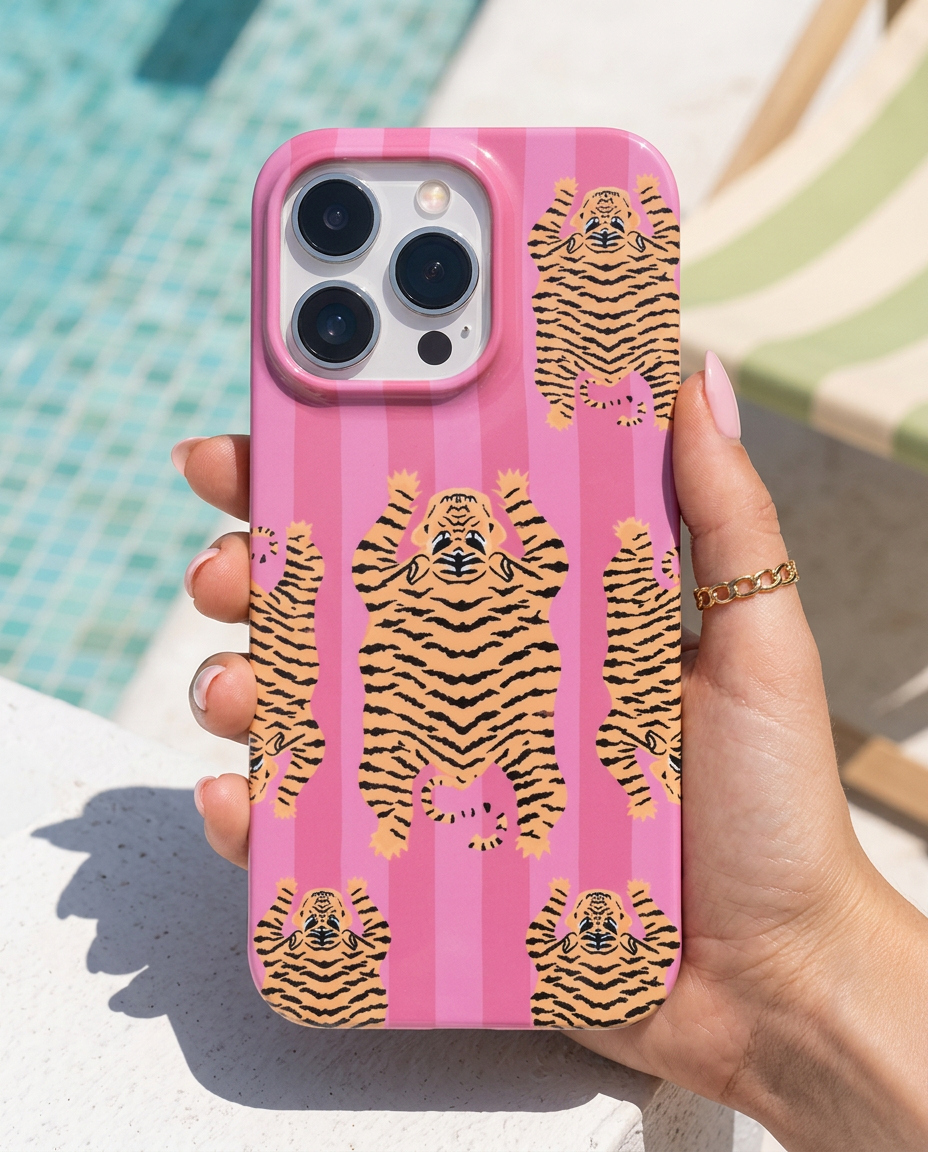 The Tibetan Tiger iPhone Case in Pink — modern editorial poolside shot with chalk-white concrete and pistachio parasols
