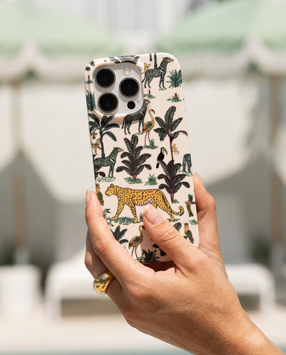 The Jungle iPhone Case in Cream tilted to the sky from a tanned hand with chunky gold dome signet ring