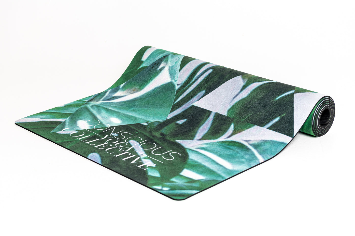 conscious yoga collective yoga mat with  leave print on a white background with triangle overlay